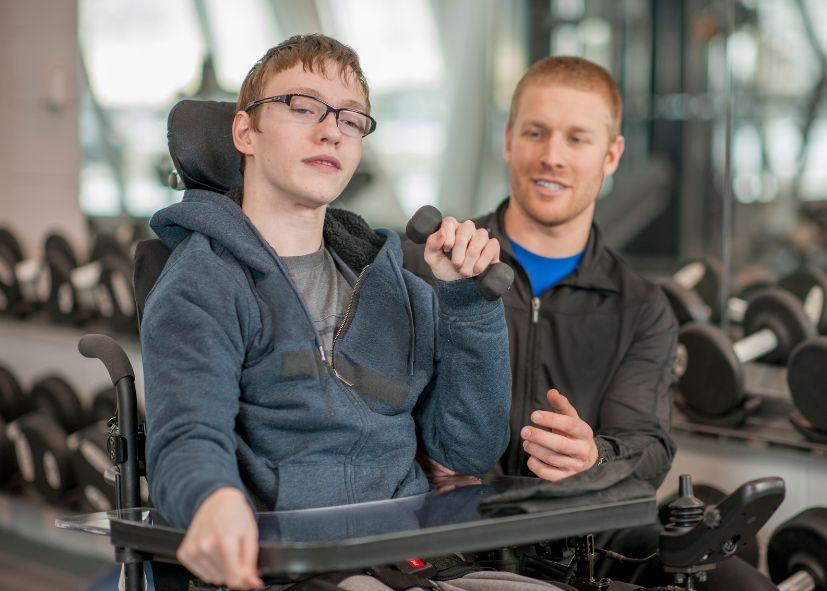 Jongeman in rolstoel in de sportschool