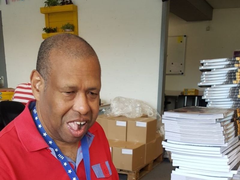 jongeman, glimlachend en trots tijdens zijn werk